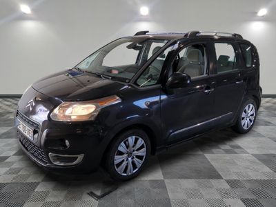 the small black car is parked on a checkered floor