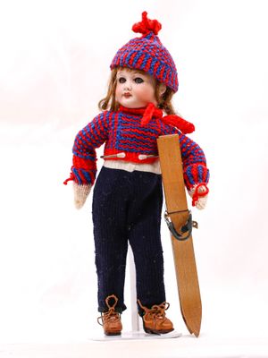 une poupée qui tient un skateboard et porte un chapeau