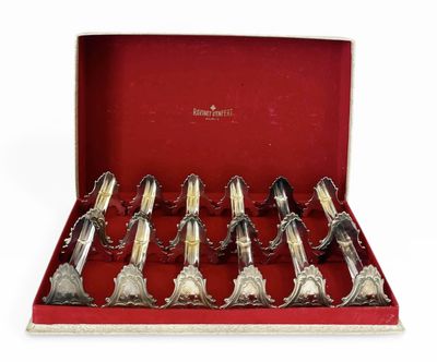 six cuillères en argent dans une boîte rouge posée sur une surface blanche