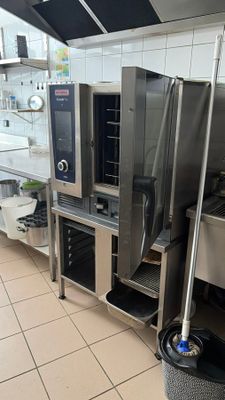 une cuisine professionnelle équipée d'appareils électroménagers en inox et d'une poubelle