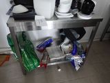 une table en métal sur laquelle sont posés tout un tas d'assiettes et de tasses