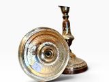 a silver and gold candle holder on a white background