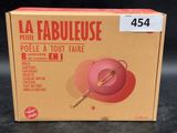 a box that has a pink bowl and a wooden spoon in it
