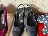 three pairs of women ' s shoes sitting on a box