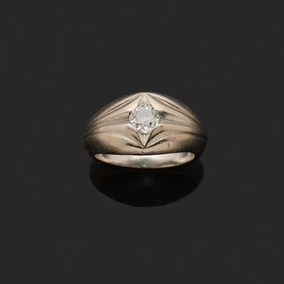 un gros plan d'une bague sertie d'un diamant, posée sur une surface noire