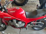 a red motorcycle parked in a garage next to other motorcycles