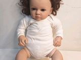 a baby doll that is sitting on a white surface