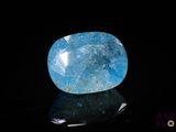 a close up of a blue stone on a black surface