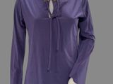 the mannequin is wearing a purple shirt and black pants
