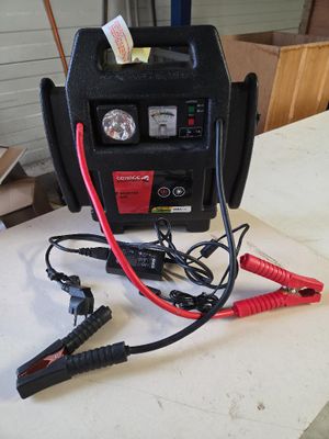 un chargeur de batterie de voiture posé sur une table, auquel est branché un chargeur