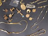 a lot of gold jewelry on a black table