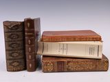trois livres sont empilés sur une surface blanche