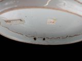 a white bowl with a brown rim and a small hole in the middle