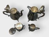 four pieces of silverware including a teapot, teapot, and spoon