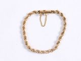a close up of a gold bracelet with a chain on a white background