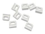 a pile of white plastic clips on a white surface