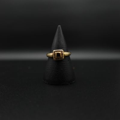 un gros plan d'une bague en or posée sur un cône noir
