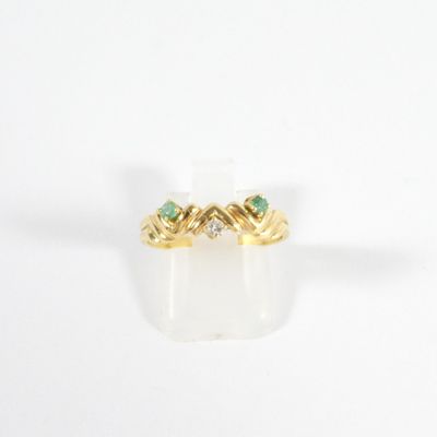 a close up of a gold ring with two emerald stones