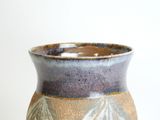 a close up of a vase on a white surface