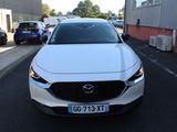 a white mazda vehicle parked on the side of the road
