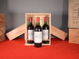 three bottles of wine in a wooden box on a table