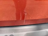 a reflection of a person standing in the reflection of a car