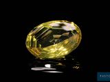 a close up of a yellow diamond on a black surface