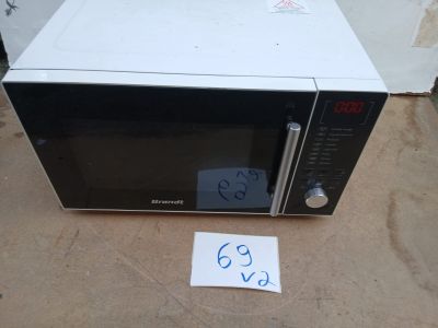 un micro-ondes posé par terre, avec une étiquette de prix dessus
