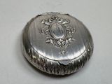 a small silver box with a monogram on it