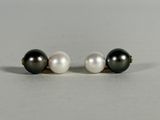 a pair of black and white pearls on a white surface