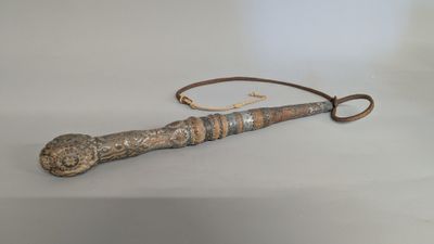 an old wooden stick with a metal handle sitting on a table