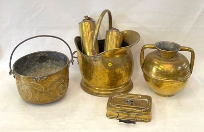 Plusieurs objets anciens en laiton sont exposés sur un support blanc