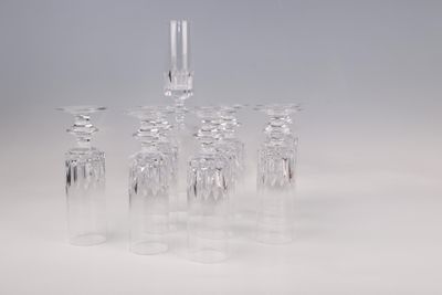 cinq verres à vin transparents posés sur une surface blanche
