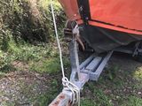 a boat tied up to a trailer on the side of the road