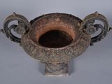 an old metal vase with a handle on a table