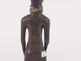 a wooden statue of a man with a beaded neck
