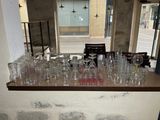 de nombreux verres vides posés sur un comptoir dans une pièce