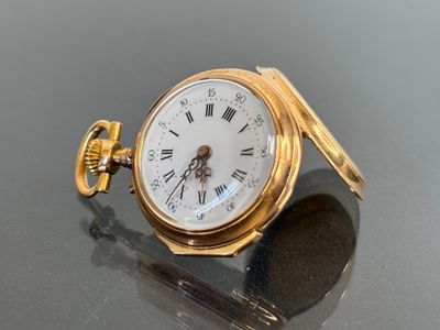 a gold pocket watch with roman numerals on it