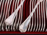 a lot of silver spoons and spoons on a red tray