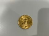 a close up of a gold coin sitting on top of a white surface
