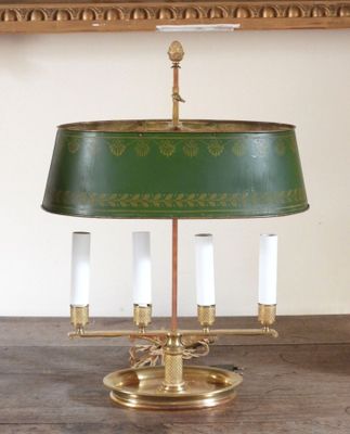a green lamp that is on a wooden table