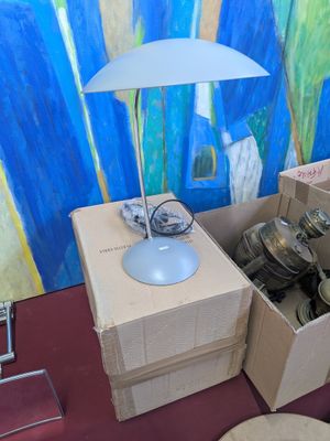 a table with a lamp on top of it next to a box of silverware
