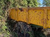 a yellow dump truck that is parked on the side of the road
