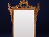 an antique gold framed mirror against a dark blue background