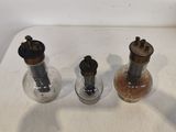 trois moulins à poivre à l'ancienne posés sur une table