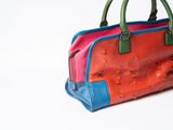 brightly colored handbag on a white surface with a white background