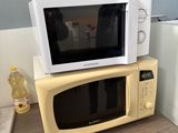 un micro-ondes posé sur un four à micro-ondes