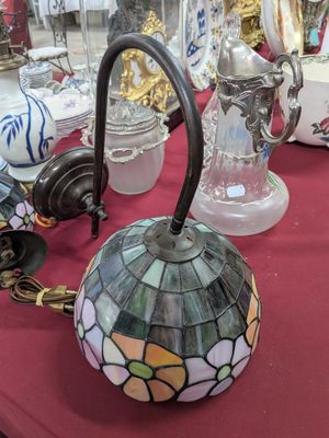 une table sur laquelle se trouve une lampe et de nombreux autres objets