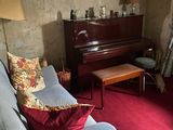 a living room with a couch, chair, and piano in it