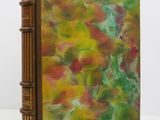 an old book with a painting on it sitting on top of a table